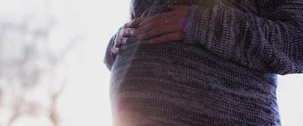 woman in jumper with a pregnant belly