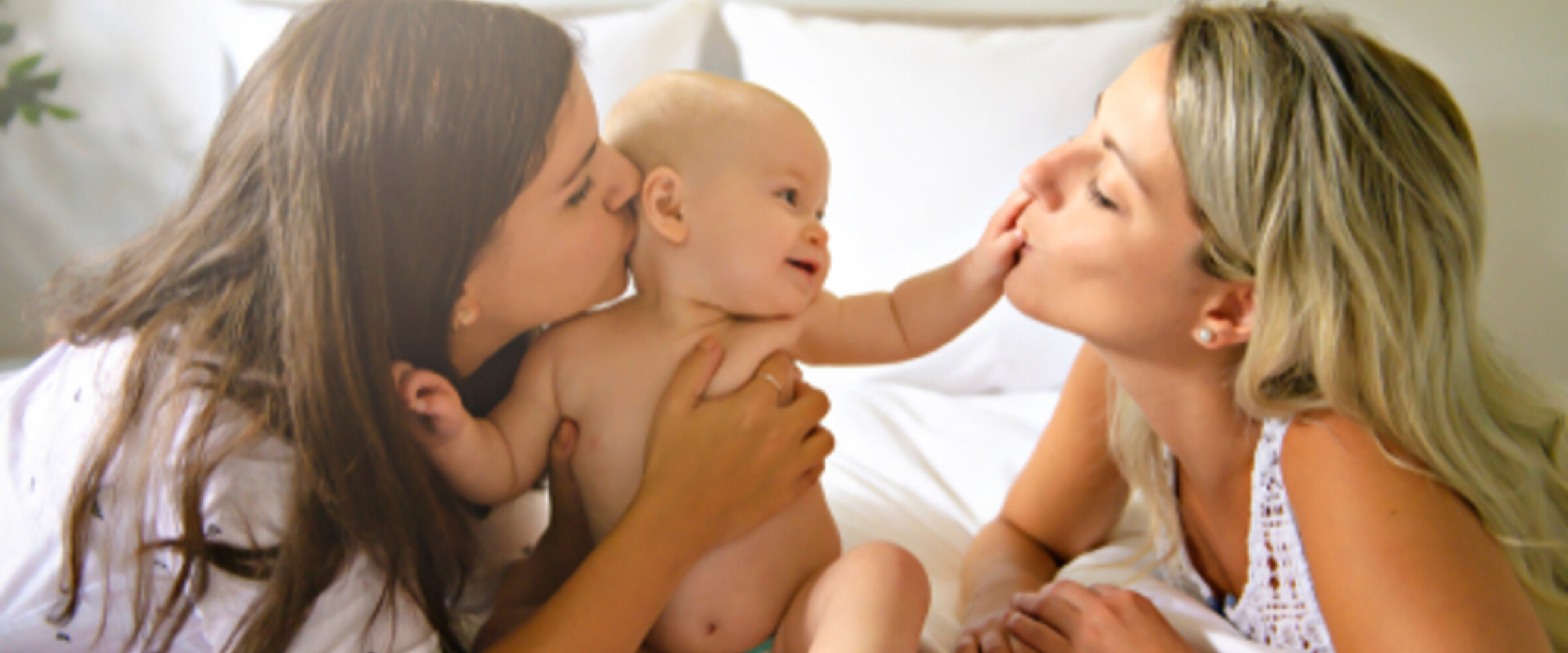 two women hugging a baby